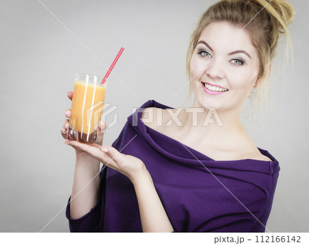 Happy woman holding fresh orange juice 112166142