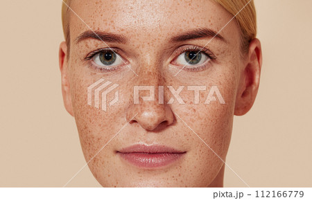 Close-up studio shot of a young female with freckles. Portrait of natural beauty woman with smooth skin against pastel backdrop. Close-up studio shot of a young female with freckles. Portrait of natural beauty woman with smooth skin against pastel backdrop. 112166779