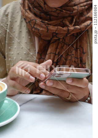 women hand holding smart phone sitting on cafe women hand holding smart phone sitting on cafe 112166984