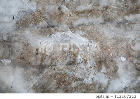 Ice covers the pavement on the sidewalk, close-up. Frozen puddle 112167212