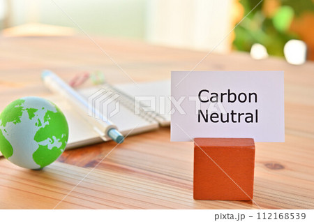 Carbon Neutralと書かれたカードと地球のボールがあるテーブル Carbon Neutralと書かれたカードと地球のボールがあるテーブル 112168539