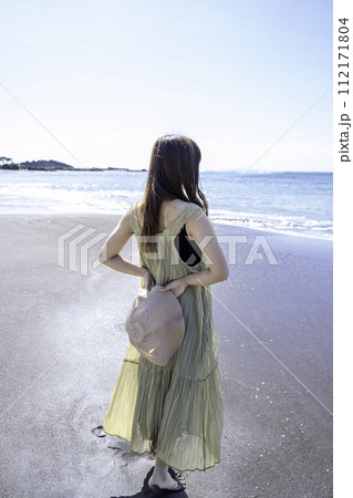 砂浜を散策するワンピースの女性 112171804