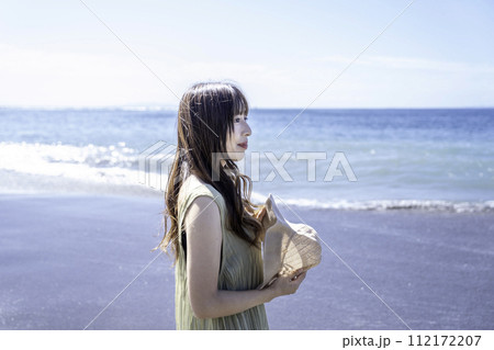 海岸を散策するワンピースの女性 海岸を散策するワンピースの女性 112172207
