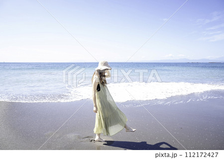 海岸を散策するワンピースの女性 海岸を散策するワンピースの女性 112172427