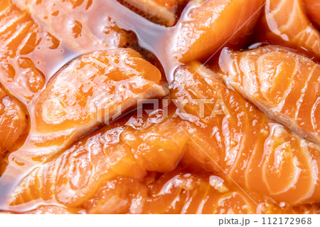 ヅケサーモン調理シーン。サーモン切り身を漬けだれに漬ける。 112172968