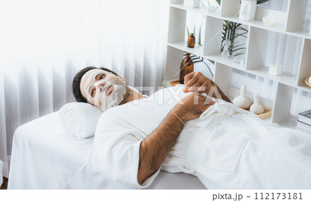 Woman customer indulges in rejuvenating with facial skincare mask. Quiescent Woman customer indulges in rejuvenating with facial skincare mask. Quiescent 112173181