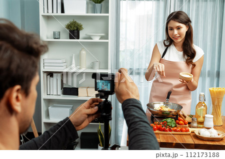 Cameraman recording to woman in chef influencer cooking spaghetti. Postulate. Cameraman recording to woman in chef influencer cooking spaghetti. Postulate. 112173188