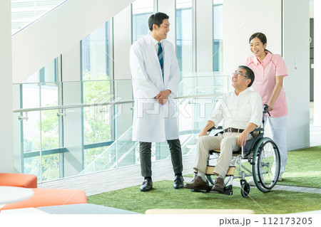 車いすのシニアと介護する若いヘルパー 車いすのシニアと介護する若いヘルパー 112173205