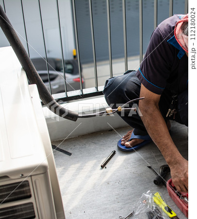 Technician  install  air conditioner outdoor unit 112180024