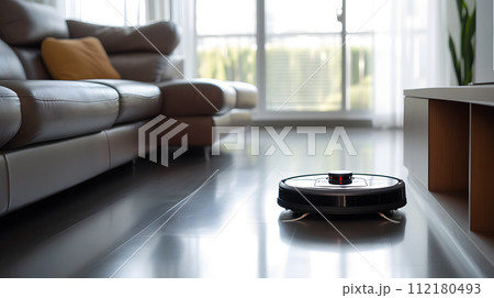 close up of a robotic vacuum glides seamlessly across a polished hardwood floor close up of a robotic vacuum glides seamlessly across a polished hardwood floor 112180493