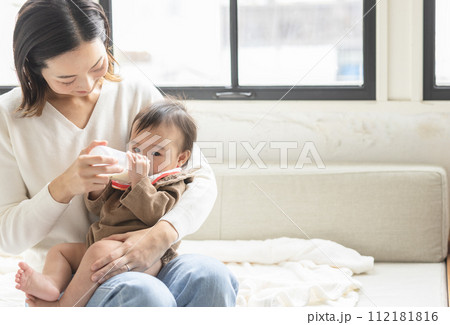赤ちゃんにミルクを飲ませる母親 112181816