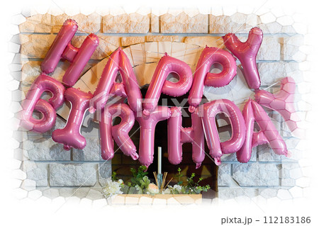 Pink inscription Happy Birthday on a brick wall by the fireplace 112183186