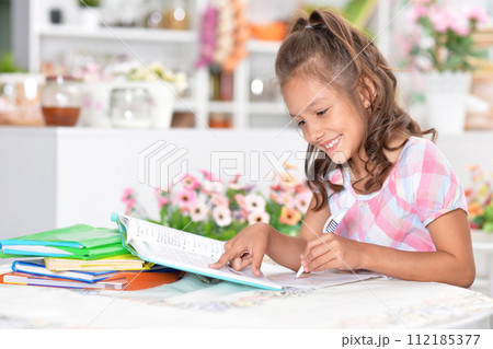 Portrait of happy schoolgirl studying at home Portrait of happy schoolgirl studying at home 112185377