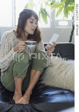 A cozy moment with coffee and a smartphone. A cozy moment with coffee and a smartphone. 112185780