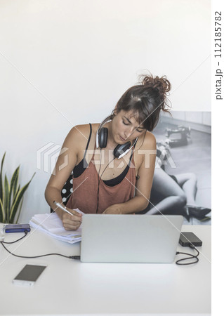 A dedicated student immerses herself in study with her laptop 112185782