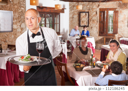 Waiter in white shirt holding tray 112186245