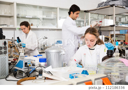 Woman lab technician writing report on chemical experiments 112186336
