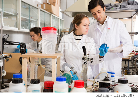 Two young technicians discussing while working 112186397