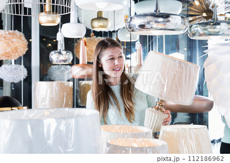 girl touching torchere in furniture store girl touching torchere in furniture store 112186962