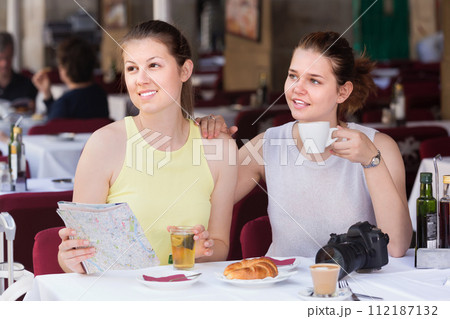 Portrait of cheeful girls with map talking Portrait of cheeful girls with map talking 112187132