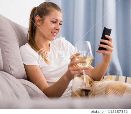 Young female with modern mobile and wine 112187353