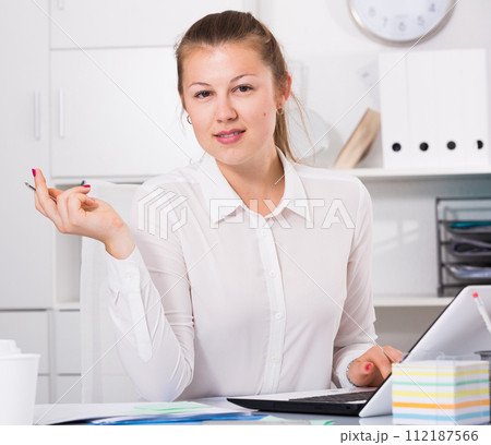 Female is posing while working behind laptop Female is posing while working behind laptop 112187566