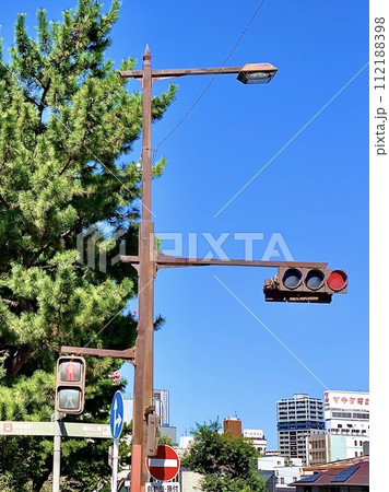秋晴れの青空に映える年季の入った街路灯付き信号機〈明代橋北交差点/愛知県岡崎市〉 112188398