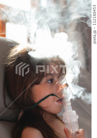 Calm child girl using nebuliser mask Calm child girl using nebuliser mask 112188453