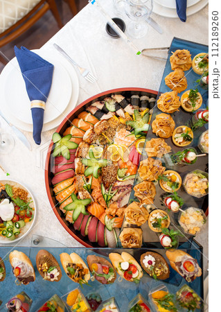 Delectable buffet spread of seafood, sushi, salads, fruit, and pastries. 112189260