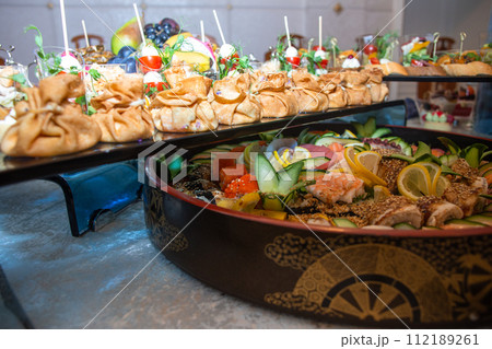 A buffet in a chic hotel with seafood, sushi, salads, fruits and pastries. 112189261