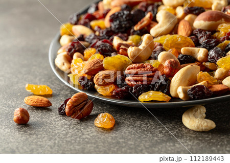 Mix of dried nuts and raisins on a rustic background. Mix of dried nuts and raisins on a rustic background. 112189443