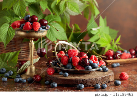 Berries with leaves on an old brown table. 112189462
