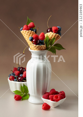 Fresh berries in waffle cones. 112189463