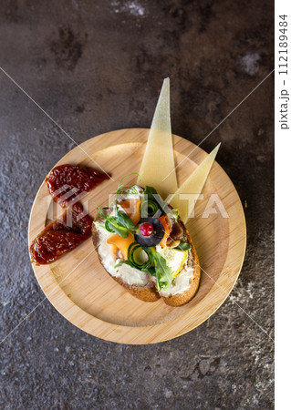 Delicious open-faced sandwich with cream cheese, cucumber, capers, herbs, cheese, and sauce 112189484