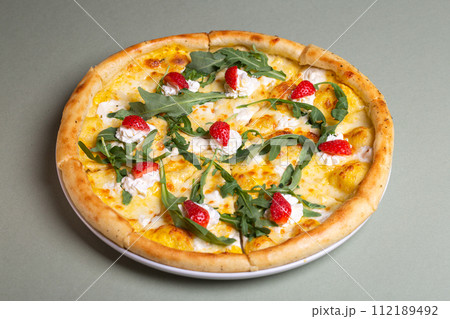 Freshly Baked Pizza with Strawberries, Cream Cheese, and Arugula on White Plate - Summer Party Theme 112189492