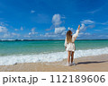 Young woman  stands barefoot on the beach 112189606