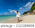Young woman walks barefoot on the beach 112189608