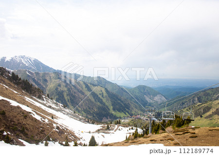 Picturesque Mountain Landscape with Lush Greenery and Snow-capped Peaks in the Distance Picturesque Mountain Landscape with Lush Greenery and Snow-capped Peaks in the Distance 112189774