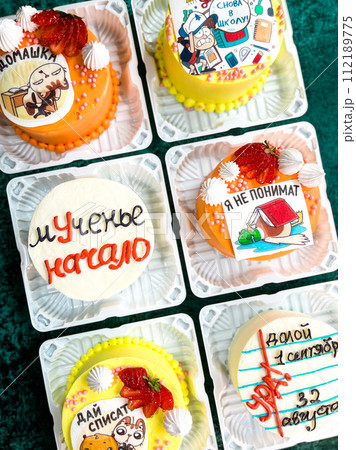Colorful Cupcakes with Intricate Frosting Designs in Plastic Containers on Green Background 112189775