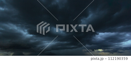 The dark sky with heavy clouds converging and a violent storm before the rain.Bad or moody weather sky and environment. carbon dioxide emissions, greenhouse effect, global warming, climate change. 112190359