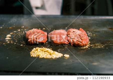 【#鉄板焼】ステーキ肉を焼くシェフの手元 112190933