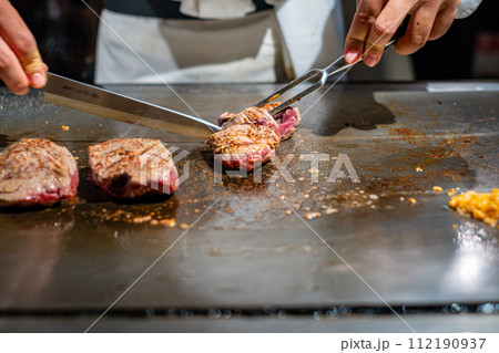 【#鉄板焼】ステーキ肉を焼くシェフの手元 【#鉄板焼】ステーキ肉を焼くシェフの手元 112190937