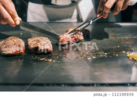 【#鉄板焼】ステーキ肉を焼くシェフの手元 【#鉄板焼】ステーキ肉を焼くシェフの手元 112190939