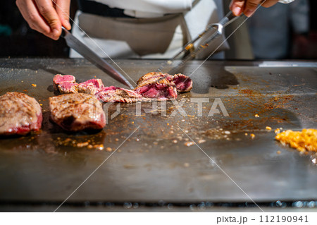 【#鉄板焼】ステーキ肉を焼くシェフの手元 【#鉄板焼】ステーキ肉を焼くシェフの手元 112190941