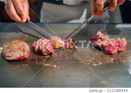 【#鉄板焼】ステーキ肉を焼くシェフの手元 112190944