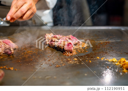【#鉄板焼】ステーキ肉を焼くシェフの手元 112190951