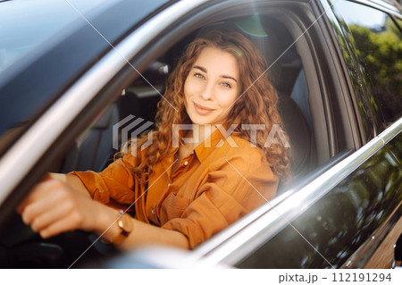 Smiling woman driving a car. Young traveler driving. Car travel, lifestyle concept. Smiling woman driving a car. Young traveler driving. Car travel, lifestyle concept. 112191294