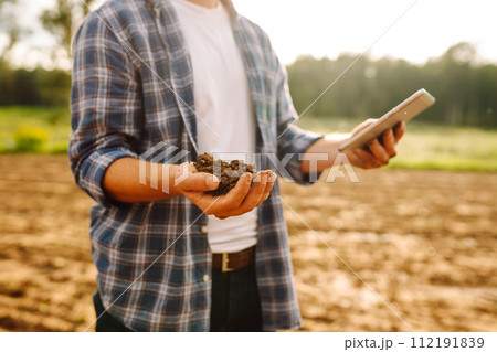 Gardening or ecology concept. Farmer's hands collects soil and checks its health before growing crop Gardening or ecology concept. Farmer's hands collects soil and checks its health before growing crop 112191839