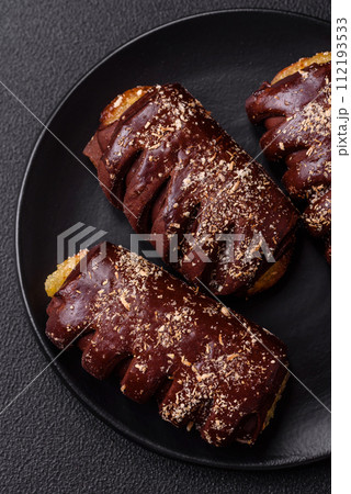 Delicious sweet chocolate cakes with fruit filling and sprinkles on a ceramic plate Delicious sweet chocolate cakes with fruit filling and sprinkles on a ceramic plate 112193533