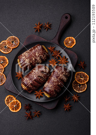 Delicious sweet chocolate cakes with fruit filling and sprinkles on a ceramic plate 112193589